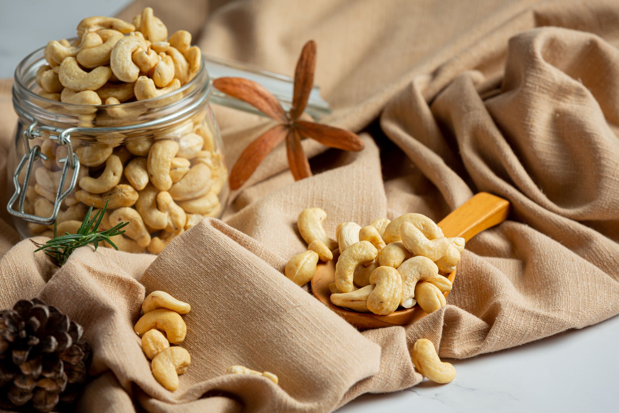 raw-cashews-nuts-open-glass-jar-marble-background